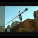 timelapse of a tower crane taking out its own tower sections